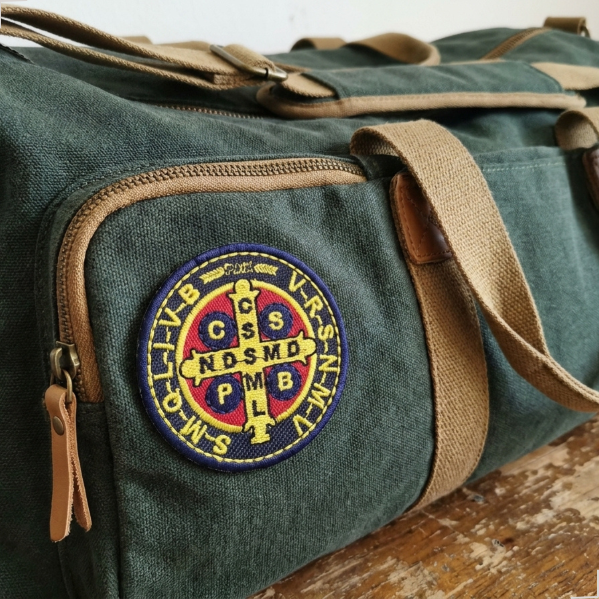 Patch bordado Medalha de São Bento aplicado em mala de viagem verde de lona